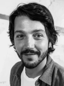 Retrato en blanco y negro del actor Diego Luna sonriendo con camiseta blanca.